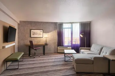 a living room with a couch and a desk at Holiday Inn Philadelphia Arpt-Stadium Area by IHG in Philadelphia