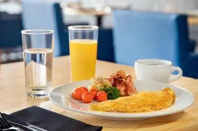a plate of breakfast food and a glass of orange juice at Holiday Inn Philadelphia Arpt-Stadium Area by IHG in Philadelphia
