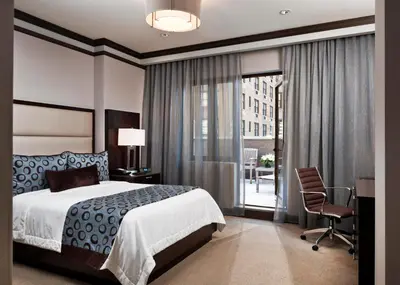 a bedroom with a bed and a desk and a chair at The Pearl Hotel in New York