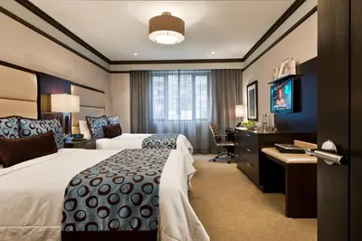 a hotel room with two beds and a desk at The Pearl Hotel in New York