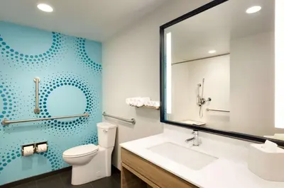 a bathroom with a toilet and a sink and a mirror at Tru By Hilton York Pa in York