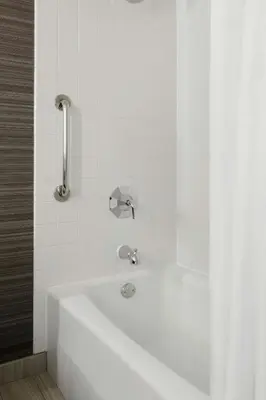 a white bath tub with a faucet in a bathroom at Newark Liberty International Airport Marriott in Newark