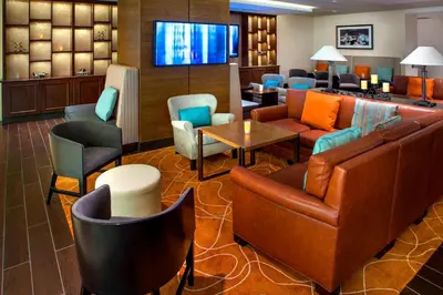 a hotel lobby with furniture and a flat screen tv at Newark Liberty International Airport Marriott in Newark