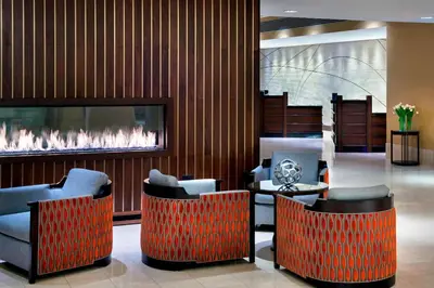 a lobby with two chairs and a fireplace at Newark Liberty International Airport Marriott in Newark