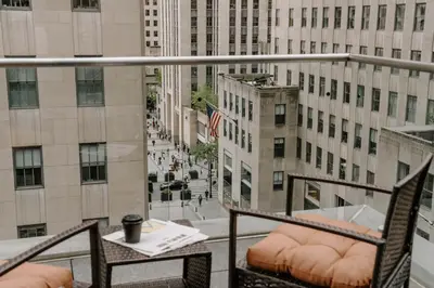 a balcony with a table and chairs and a view of a city at The Jewel Hotel, New York in New York