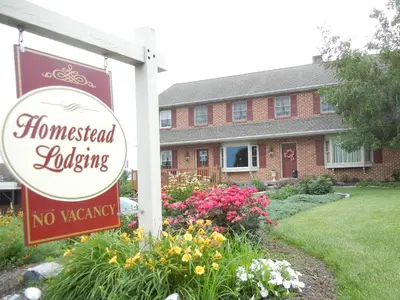 a house with a no vacancy sign in front of a yard at Homestead Lodging in Smoketown