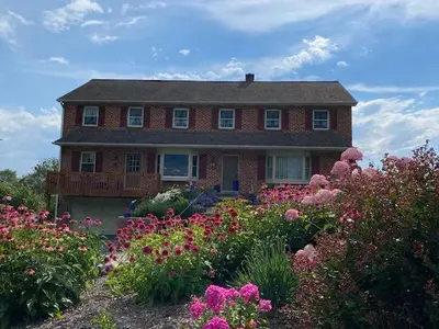 a house with a bunch of flowers in front of it at Homestead Lodging in Smoketown