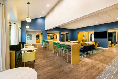a lobby with tables and chairs and a cafeteria at Sonesta Select Philadelphia Airport in Philadelphia