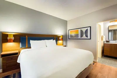a bedroom with a large white bed and a bathroom at Sonesta Select Philadelphia Airport in Philadelphia