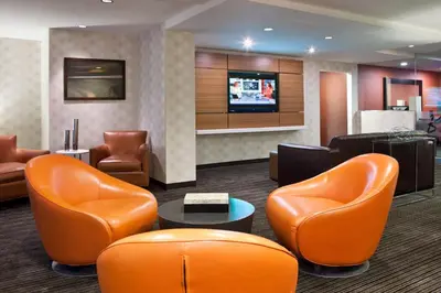 a lobby with orange chairs and a flat screen tv at Residence Inn by Marriott Philadelphia Center City in Philadelphia