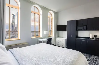 a bedroom with a white bed and a desk and windows at Residence Inn by Marriott Philadelphia Center City in Philadelphia