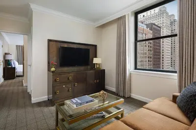 a living room with a couch and a tv and a window at The Ritz-Carlton, Philadelphia in Philadelphia