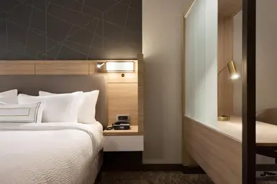 a hotel room with a bed and a desk with a clock at SpringHill Suites by Marriott Allentown Bethlehem/Center Valley in Center Valley