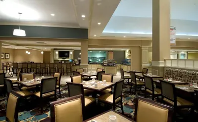 a restaurant with tables and chairs in a room at Hilton Garden Inn Mount Holly/Westampton in Westampton Township