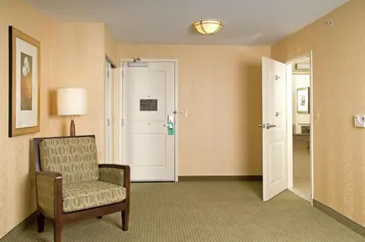 a hotel room with a chair and a door at Hilton Garden Inn Mount Holly/Westampton in Westampton Township