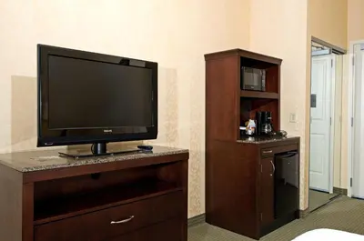 a flat screen tv sitting on top of a wooden entertainment center at Hilton Garden Inn Mount Holly/Westampton in Westampton Township