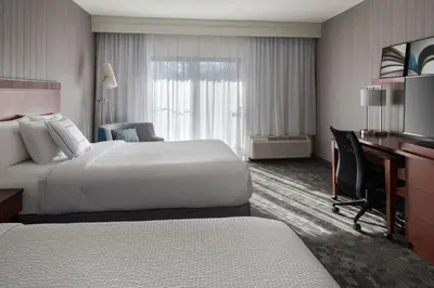 a hotel room with two beds and a desk at Courtyard by Marriott Mahwah in Mahwah