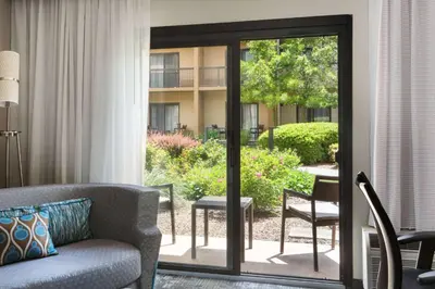 a living room with a couch and a sliding glass door at Sonesta Select Whippany Hanover in Whippany
