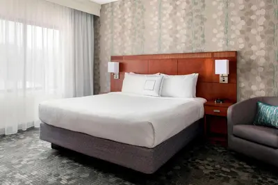 a hotel room with a bed and a chair at Sonesta Select Whippany Hanover in Whippany