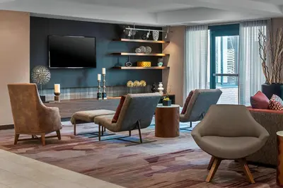 a living room with chairs and a flat screen tv at Courtyard By Marriott Jersey City Newport in Jersey City