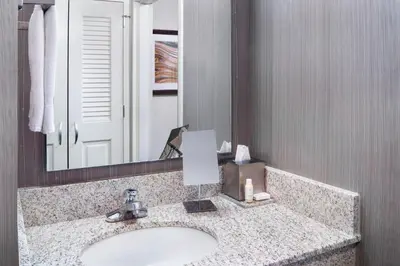 a bathroom with a sink and a mirror at Courtyard By Marriott Jersey City Newport in Jersey City