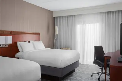 a hotel room with two beds and a desk at Courtyard Philadelphia Devon/Villanova in Wayne