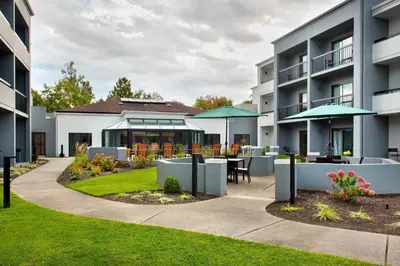 an exterior view of a apartment building with a patio at Courtyard Philadelphia Devon/Villanova in Wayne