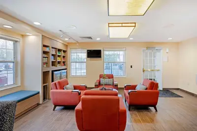 a waiting room with couches and a tv and windows at MainStay Suites Mt Laurel - Philadelphia in Mount Laurel