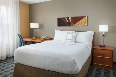 a large bed in a hotel room with a desk at MainStay Suites Mt Laurel - Philadelphia in Mount Laurel