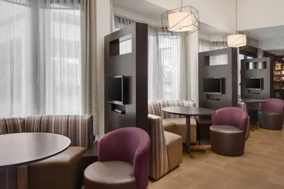a waiting room with tables and chairs and televisions at Courtyard Philadelphia Willow Grove in Willow Grove