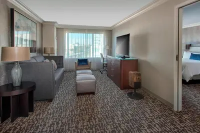 a hotel room with a couch and a bed and a television at Marriott Philadelphia West in West Conshohocken