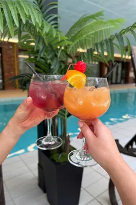 two hands holding two cocktails in front of a pool at Princeton Marriott at Forrestal in Princeton