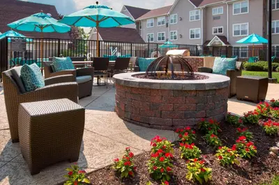 a patio with a fire pit and chairs and flowers at Sonesta ES Suites Allentown Bethlehem Airport in Bethlehem