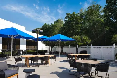 a patio with tables and chairs and blue umbrellas at Marriott Park Ridge in Park Ridge