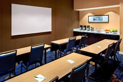 a restaurant with wooden tables and chairs and a whiteboard at Courtyard Parsippany in Parsippany