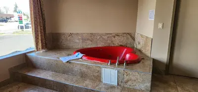a red bath tub in the corner of a bathroom at Town House Inn and Suites in Elmwood Park