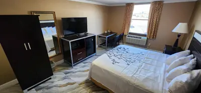 a bedroom with a bed and a flat screen tv at Town House Inn and Suites in Elmwood Park