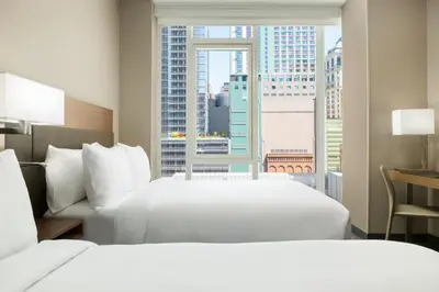 a hotel room with two beds and a large window at AC Hotel by Marriott New York Times Square in New York