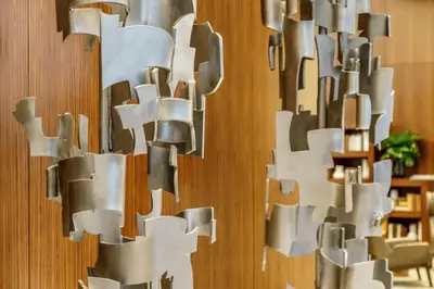 a large metal sculpture on a wooden wall at AC Hotel by Marriott New York Times Square in New York