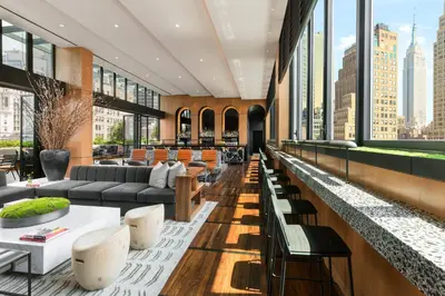 a lobby with couches and tables and windows at AC Hotel by Marriott New York Times Square in New York