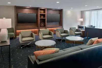a hotel room with a couch and chairs and a tv at Courtyard Philadelphia Plymouth Meeting in Plymouth Meeting