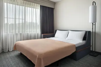 a bedroom with a bed and a large window at Courtyard Philadelphia Plymouth Meeting in Plymouth Meeting