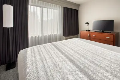 a hotel room with a bed and a flat screen tv at Courtyard Philadelphia Plymouth Meeting in Plymouth Meeting