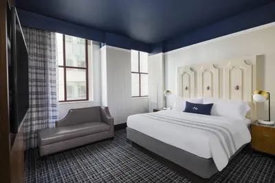 a bedroom with a large bed and a chair at The Notary Hotel, Philadelphia, Autograph Collection in Philadelphia
