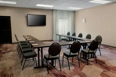 a conference room with tables and chairs and a flat screen tv at Courtyard by Marriott Mt. Laurel in Mount Laurel