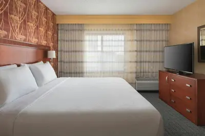 a hotel room with a bed and a flat screen tv at Courtyard by Marriott Mt. Laurel in Mount Laurel