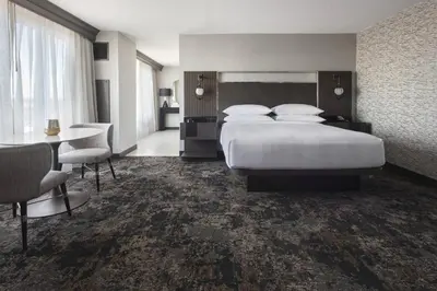 a hotel room with a large bed and a table at Bridgewater Marriott in Bridgewater