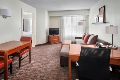 a hotel room with a couch and a table and a desk at Residence Inn by Marriott Somerset in Somerset