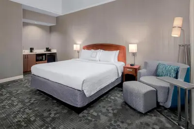 a hotel room with a bed and a chair at Courtyard by Marriott Basking Ridge in Basking Ridge