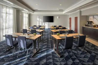 a conference room with tables and chairs and a tv at Courtyard by Marriott Basking Ridge in Basking Ridge